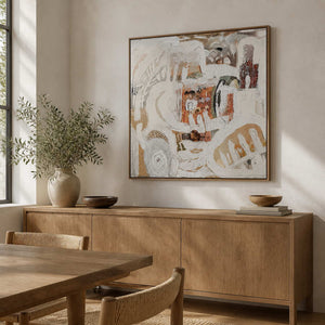 Wood framed cream and rust abstract artwork above an oak dining room sideboard.