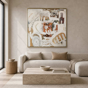 Gold framed textured abstract artwork above a cream sofa beside a sunlit window.