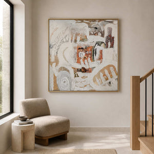 Gold framed textured abstract artwork beside a reading chair on a bright staircase landing.