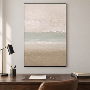 Hand-painted coastal canvas in warm ivory, sea-glass green, and sand, displayed in a study in a black frame.