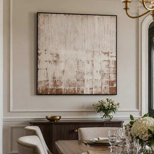 Black framed cream and brown abstract artwork above a dining room sideboard.