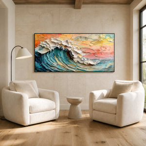 Black framed wave painting above two cream reading chairs and a small pedestal table.
