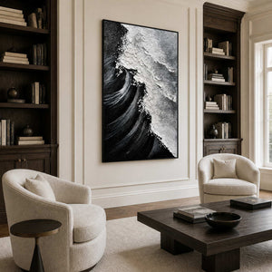 Black framed wave painting with white foam between walnut bookshelves in a reading lounge.
