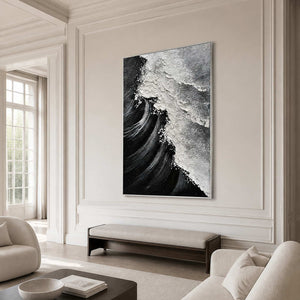 Silver framed monochrome coastal painting above a long bench in an ivory sitting room.