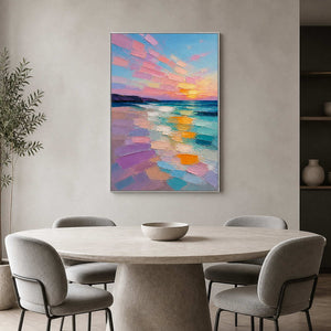 Pink and turquoise sunset artwork above a round stone dining table.