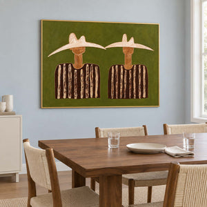 Olive-ground portrait beside a wooden dining table and woven chairs.