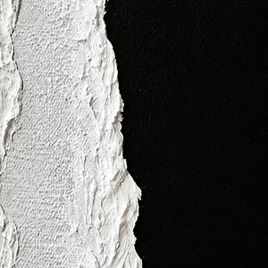 Close view of white raised seams and woven texture beside a black painted surface.