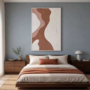 White framed curved abstract artwork above a wooden bed with cream linens.