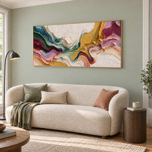 Wide color-flow artwork above a rounded cream sofa on a pale green wall.