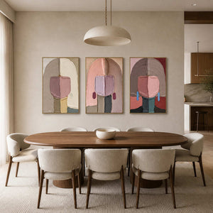 Textured figurative triptych displayed above a warm contemporary dining room.