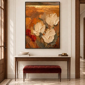 Textured cream flowers painting against an amber and rust background in a black frame in an entryway.