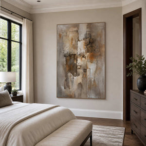 Wood-framed earthy abstract artwork beside a neutral bed, upholstered bench, and dark wooden dresser.