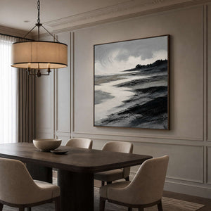 Black and gray coastal landscape wall art in a dining room with a wood frame.