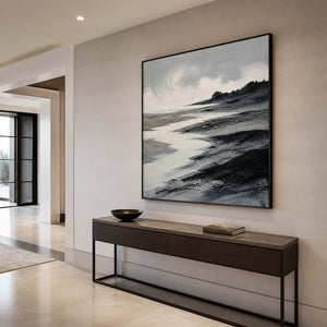 Textured ocean landscape wall art in an elegant entryway with a black frame.
