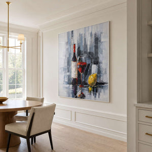 White framed wine and lemon painting beside a round breakfast table.