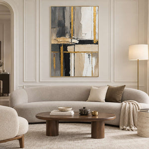 Neutral geometric painting above a curved cream sofa against a paneled wall.