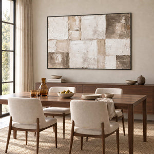 Time in Soft Focus in a black frame above a sideboard behind a wood dining table with cream chairs.