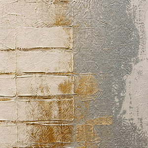 Close-up of raised ivory blocks, silver washes, and warm gold texture.
