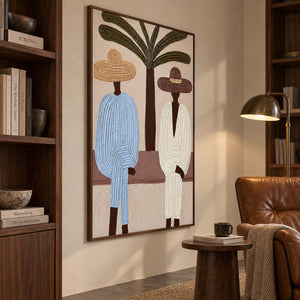 Blue and cream figurative artwork beside a leather reading chair and dark wood bookshelves.