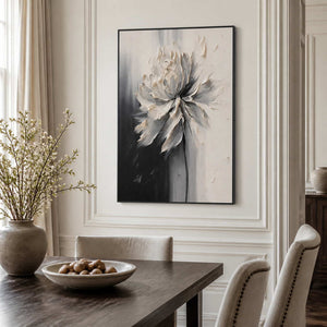 Black framed ivory flower artwork above a dark wood dining table.