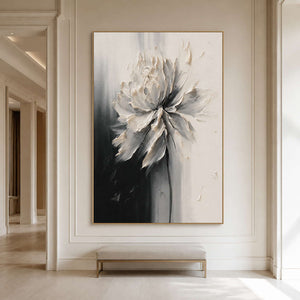 Gold framed ivory flower artwork above an upholstered bench in a hallway.
