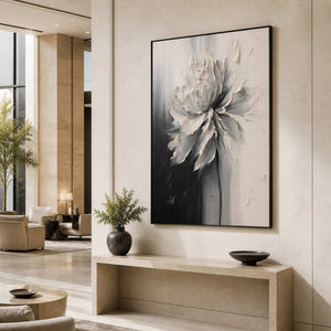 Black framed textured flower artwork above a stone console in a hotel lobby.
