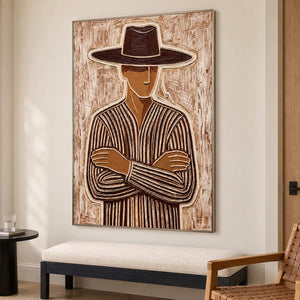 Tall folded-arm portrait over a cream bench beside a woven wooden chair.