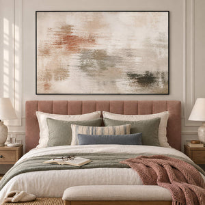 Neutral abstract painting with ivory, taupe, clay, and olive layered marks in a black frame in a bedroom.