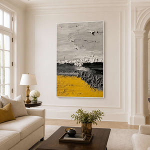 White framed textured abstract artwork beside cream seating and a dark wooden coffee table.