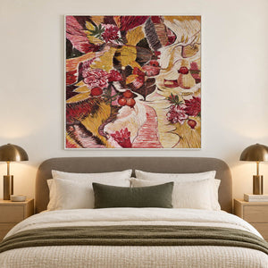 Red flowers and rounded fruit forms woven through ochre, cream and dark bands in an artwork with a white frame, displayed in a bedroom near the bed.
