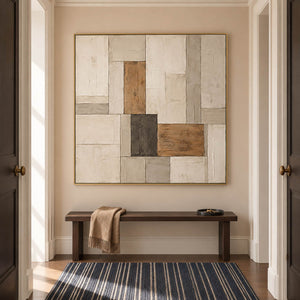 Textured ivory stone caramel and charcoal blocks in a quiet square composition, displayed in a hallway in a gold frame.