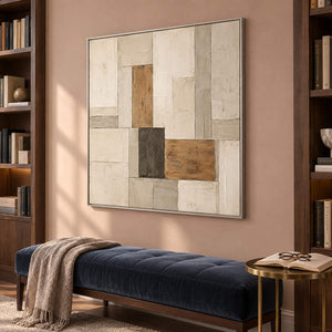 Textured ivory stone caramel and charcoal blocks in a quiet square composition, displayed in a library in a silver frame.