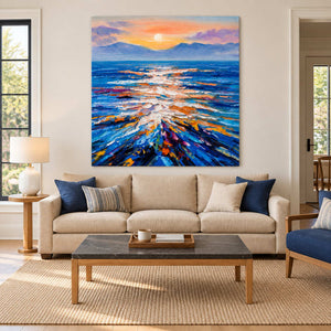 Blue and peach seascape above a beige sofa with navy cushions and a rectangular coffee table.