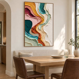 Vertical textured painting behind a wooden dining table and leather chairs.