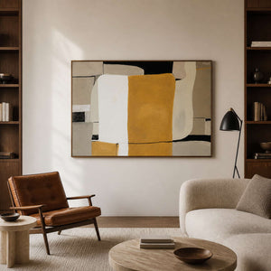Wood framed ochre abstract artwork between bookshelves in a warm reading room.