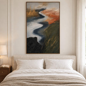 A winding pale waterway between dark green and rust-colored fields in a brown wood frame, displayed above a bed.