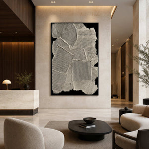 Black framed cream relief artwork near a hotel reception desk, elevators, and lounge seating.