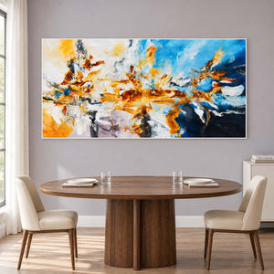 Bright abstract behind a wooden dining table and cream chairs.