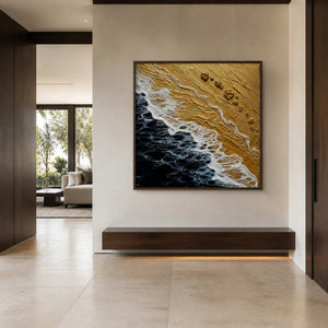 Square gold and black coastal artwork displayed in a stone entry hall.