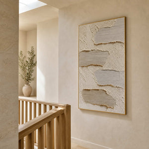 Ivory and greige abstract artwork displayed beside a light wood stairway.