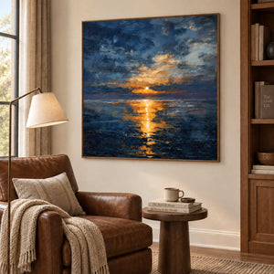 Sea reflection artwork beside a brown leather reading chair and small round side table.