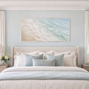 Soft blue textured coastal artwork above a calm neutral bedroom.