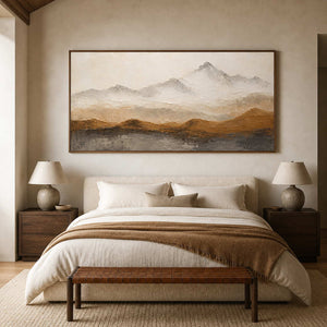 Neutral mountain landscape above a cream upholstered bedroom.