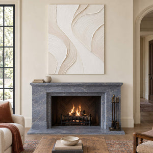 Hand-painted ivory abstract wall art with flowing cream relief and fine combed texture, displayed beside or above a fireplace without an outer frame.
