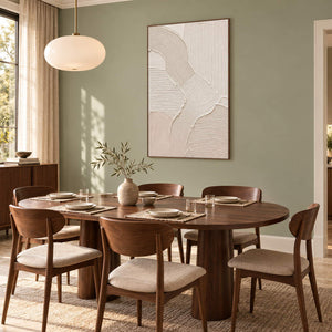 Hand-painted ivory abstract canvas with overlapping raised organic forms, displayed in a dining room in a brown wood frame.