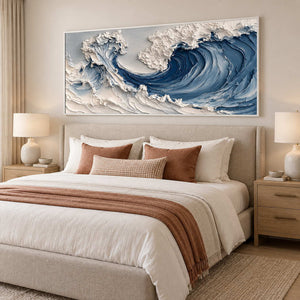 White-framed seascape above a neutral bed with rust-colored pillows and throw.