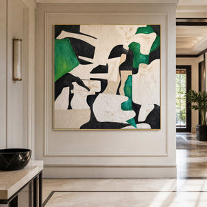 Gold framed square abstract artwork on a paneled hallway wall beside a console.