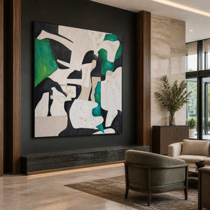 Black framed green abstract artwork above a dark ledge in a hotel lobby.