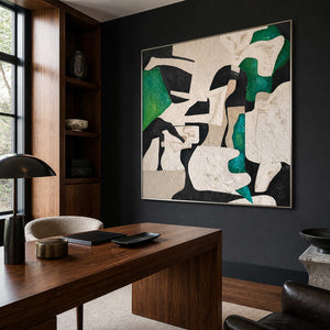 Silver framed green and black abstract artwork on a dark study wall.