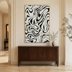 Gold framed abstract painting with bold black channels above a wooden hallway cabinet.